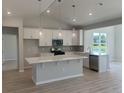 Bright kitchen featuring white cabinets, a center island with quartz countertop, and pendant lighting for a modern and functional space at 360 Kapalua Loop, Little River, SC 29566