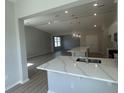 Open-concept kitchen flows into the living area with a large island, quartz countertops, and ample space for entertaining guests at 360 Kapalua Loop, Little River, SC 29566