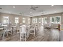 Bright community room with hardwood floors, multiple tables, chairs, and ceiling fans at 416 Kapalua Loop, Little River, SC 29566