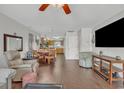 Open-concept living room that features wood flooring, ceiling fan, television, and eat-in kitchen at 4293 Parkway Ln. # 34, Little River, SC 29566