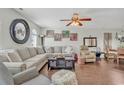 Inviting living room featuring a large sofa, ceiling fan, wood floors and plentiful natural light at 4293 Parkway Ln. # 34, Little River, SC 29566