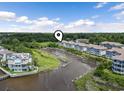 Aerial view of waterfront condos and docks surrounded by lush green marshland and vegetation at 4405 Eastport Blvd. # D-8, Little River, SC 29566