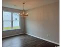 Dining room with modern chandelier, a large window with outside view, and wood-look flooring at 453 Kapalua Loop, Little River, SC 29566