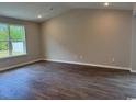 Open living area with hardwood floors, neutral paint and a large window for plenty of natural light at 453 Kapalua Loop, Little River, SC 29566