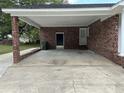 Spacious carport featuring a brick support column and access doors, perfect for vehicle storage at 506 Byrnes Circle, Johnsonville, SC 29555