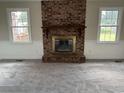Cozy living room with a brick fireplace as the focal point and two windows that let in natural light at 506 Byrnes Circle, Johnsonville, SC 29555