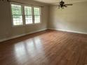 Bright and airy living room with hardwood flooring, a ceiling fan, and large windows offering ample light at 506 Byrnes Circle, Johnsonville, SC 29555