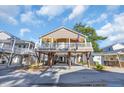 Charming two-story beach home on pilings, showcasing a welcoming porch and well-maintained landscaping at 6001-O32 S Kings Hwy., Myrtle Beach, SC 29575