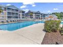 Inviting swimming pool surrounded by lounge chairs and landscaped grounds for relaxation and enjoyment at 602 Waterway Village Blvd. # 30-F, Myrtle Beach, SC 29579