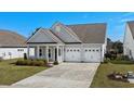 An inviting one-story home with a landscaped yard and a two-car attached garage at 617 Cherry Blossom Dr., Murrells Inlet, SC 29576