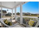 Relaxing front porch with white wicker chairs and a charming view of the neighborhood at 617 Cherry Blossom Dr., Murrells Inlet, SC 29576