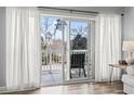 A cozy balcony with outdoor seating is seen through glass doors and white curtains at 1017 World Tour Blvd. # 206, Myrtle Beach, SC 29579