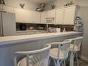 Well-lit kitchen with white cabinets, breakfast bar, and unique coastal decorative touches at 1058 Sea Mountain Hwy. # 14-203, North Myrtle Beach, SC 29582