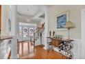 Welcoming foyer with hardwood floors, elegant lighting, stairs to upper level, and decorative console table at 1606 Lake Egret Dr., North Myrtle Beach, SC 29582