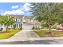 Beautiful two-story home boasts a long driveway and a well-maintained lawn with mature trees at 307 River Rock Ln. # 906, Murrells Inlet, SC 29576