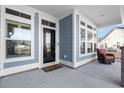 Charming front porch featuring a seating area, complemented by windows and a welcoming entrance at 5501 Bristle Cone Ct., Myrtle Beach, SC 29577