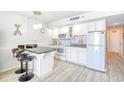 Efficient kitchen with white cabinetry, granite countertops, breakfast bar, and modern appliances at 5523 N Ocean Blvd. # 1513, Myrtle Beach, SC 29577