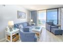 Comfortable living room with blue furniture, stylish decor, and a sliding glass door to a great view at 5523 N Ocean Blvd. # 1513, Myrtle Beach, SC 29577