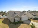 Side view of the home, showcasing its neutral siding and well-maintained landscape at 556 Cedar Lakes Dr., Little River, SC 29566