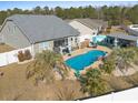 Relaxing backyard oasis with a kidney-shaped pool, complete with lounge area and bar at 556 Cedar Lakes Dr., Little River, SC 29566