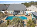 A private backyard pool with a hot tub, lounging area, and tropical landscaping at 556 Cedar Lakes Dr., Little River, SC 29566