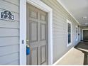 Condo entrance with gray front door, white trim, and unit number plaque at 5801 Oyster Catcher Dr. # 723, North Myrtle Beach, SC 29582