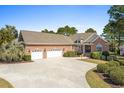 Expansive brick home boasts an oversized three-car garage and a spacious driveway at 598 Summer Green Ct., Sunset Beach, NC 28468