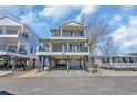Charming coastal home with a stilt foundation, multiple balconies and a covered area for parking and outdoor living at 6001-5126 S Kings Hwy., Myrtle Beach, SC 29575