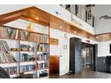 Open-concept living area with built-in bookshelves, wood ceilings, and a view to the upper floor at 604 Ocean Boulevard W, Holden Beach, NC 28462