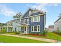 Attractive two-story blue home with a lush green lawn, enhanced by white trim and a charming porch at 67 Bridgeview Rd., Georgetown, SC 29440