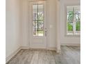 Bright entryway featuring a glass-paneled front door and light gray wood floors at 82 Bridgeview Rd., Georgetown, SC 29440