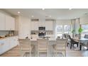 Modern kitchen featuring white cabinets, stainless steel appliances, breakfast bar, and adjacent dining area at 929 Maya Layne Dr., Little River, SC 29566