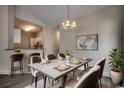 Elegant dining room with sophisticated chandelier, seating for six, and seamless transition into kitchen at 999 Algonquin Dr. # E, Pawleys Island, SC 29585