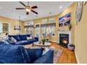 Cozy living room featuring a fireplace, plush blue seating, and scenic views from the multiple windows at 120 Henry Middleton Blvd., Myrtle Beach, SC 29588