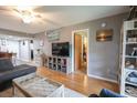 Open living room features wood floors, a large TV, and views into the dining area and hallway at 1301 Pridgen Rd. # 1101, Myrtle Beach, SC 29577