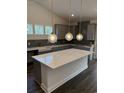 Modern kitchen featuring gray cabinets, a large island, and designer pendant lighting fixtures at 179 Glengrove Lane, Murrells Inlet, SC 29576