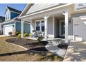 Inviting front porch featuring a seating area, landscaping, and a walkway to the home's entrance at 2049 Oxford St., Myrtle Beach, SC 29577
