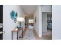Inviting hallway with decor, leading to living area and bedroom with neutral walls and wood-look floors at 212 Jeff Waters Circle, Longs, SC 29568