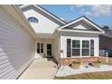 Welcoming front porch with brick accents, decorative barrels, and black shutters at 321 Cabo Loop, Myrtle Beach, SC 29588