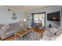 Bright living room offering a cozy atmosphere with stylish decor, comfortable seating and a TV for relaxation at 4115 Little River Rd. # 4-F, Myrtle Beach, SC 29577