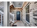 Brick entryway featuring a black door, decorative wreath, and adjacent stairway at 6253 Catalina Dr. # 1711, North Myrtle Beach, SC 29582