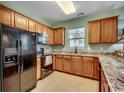 Kitchen featuring wood cabinets, granite countertops, and black appliances at 6253 Catalina Dr. # 1711, North Myrtle Beach, SC 29582