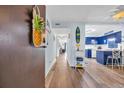 Bright hallway with a pineapple decoration opens to kitchen with blue cabinets at 6813 Porcher Dr. # 26, Myrtle Beach, SC 29572