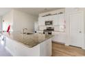 Bright kitchen with stainless steel appliances, granite countertops, a center island, and white cabinets at 723 Joywood Dr., Longs, SC 29568