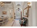 Elegant foyer with chandelier, columns, and a cushioned bench seating area at 7538 Ventura Ct., Myrtle Beach, SC 29572