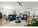 Spacious living room featuring ceiling fan, light gray walls, and gray kitchen in the background at 781 Flowering Branch Ave., Little River, SC 29566
