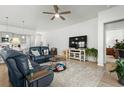 Open-concept living room with a ceiling fan and large television, open to the gray kitchen at 781 Flowering Branch Ave., Little River, SC 29566