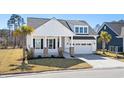 Beautiful white home with a inviting front porch, lush lawn, and two car garage at 9035 Binnicker Dr., Murrells Inlet, SC 29576