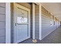 Front door with glass and welcome sign on a gray plank exterior and gray carpet at 131 Waypoint Ridge Ave. # Q29, Little River, SC 29566