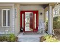 Inviting red front door with sidelights, rocking chair, and view into the living room at 1820 Spinnaker Dr., North Myrtle Beach, SC 29582